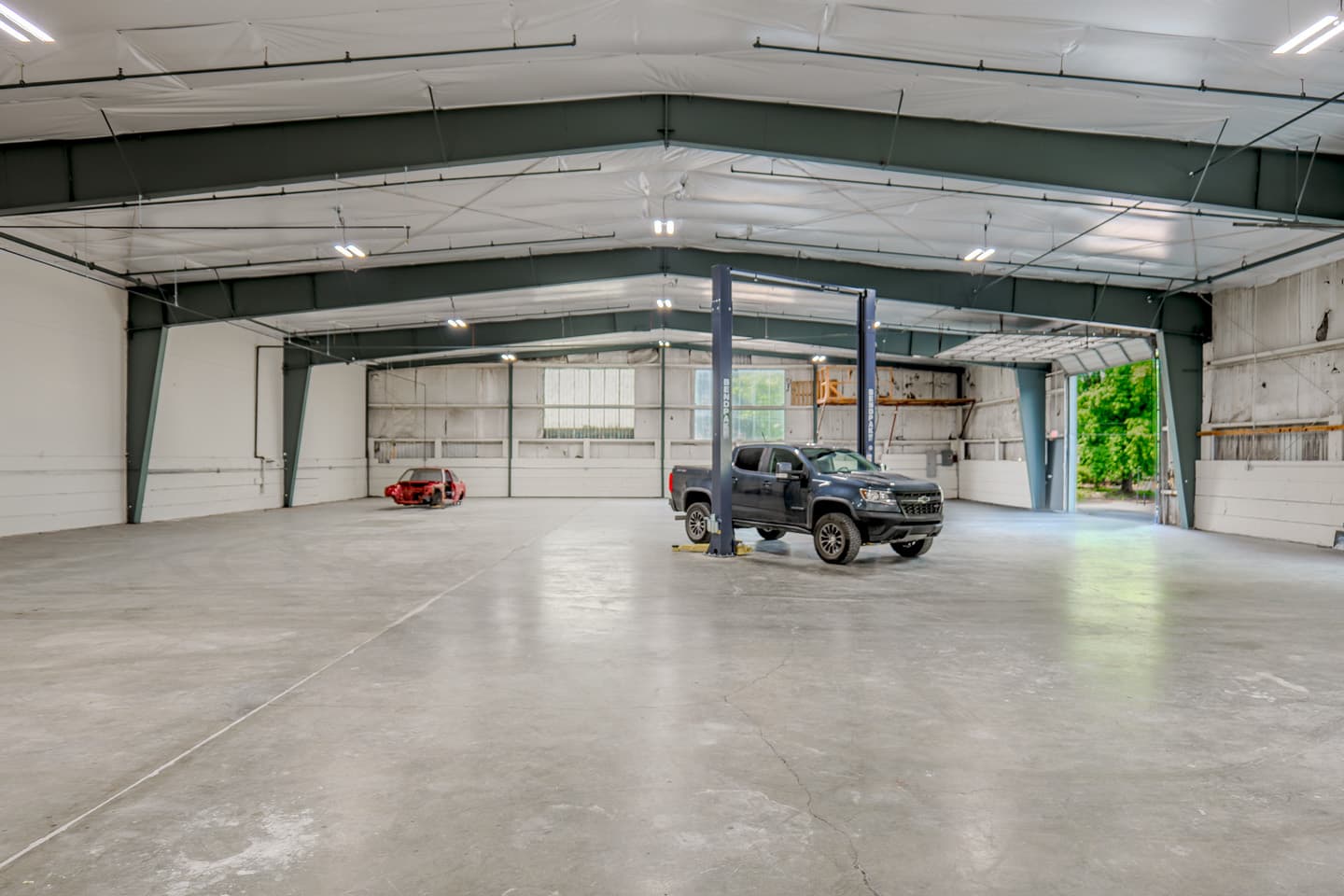 Open floor space inside the ModWerks building, with a vehicle on a lift